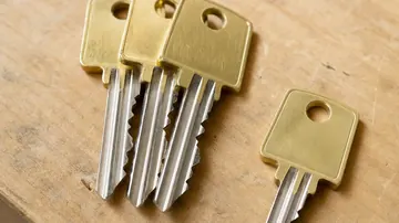 Quatre clés de sécurité en laiton et nickel sur un établi