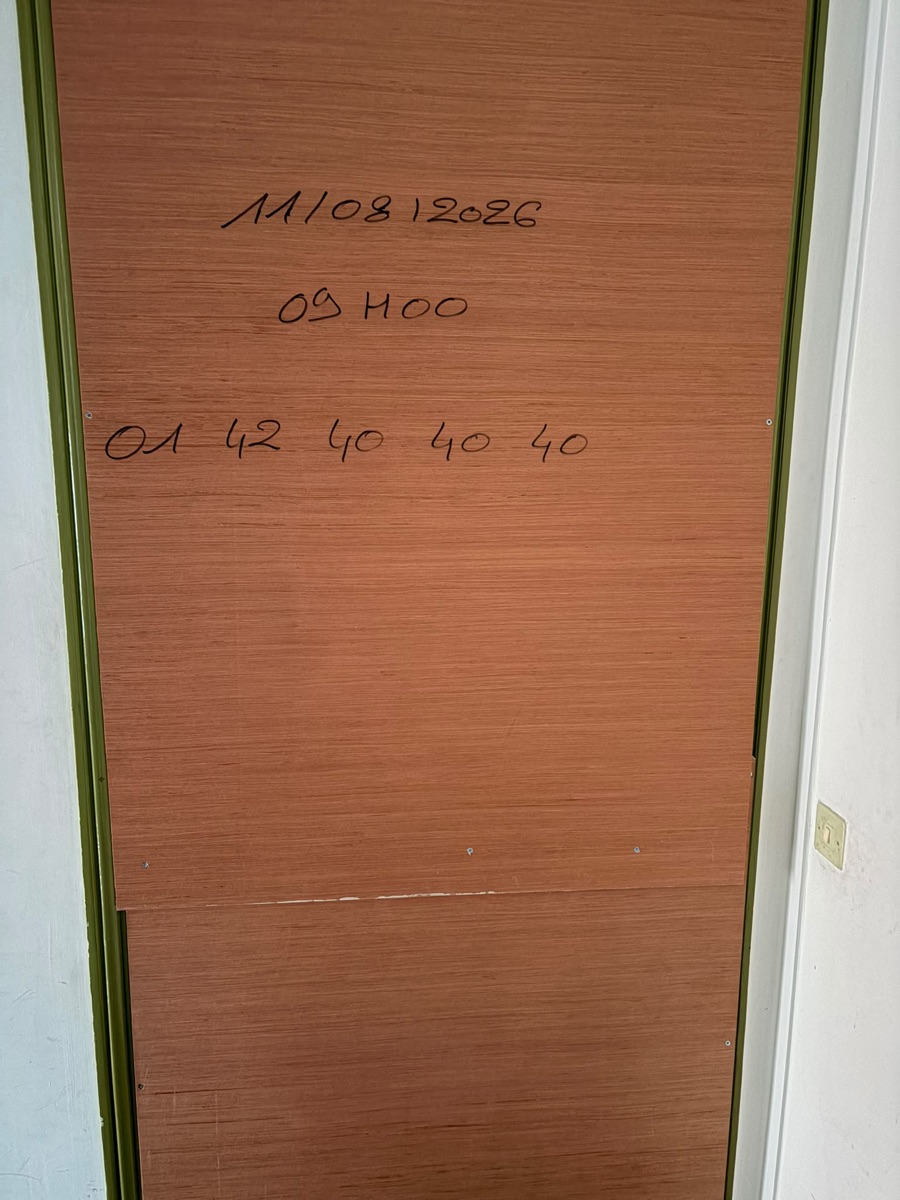 Fermeture provisoire d'une porte condamnée par panneaux de contreplaqué